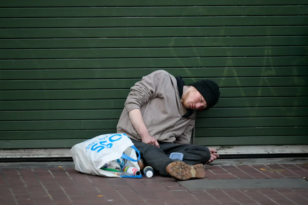 A homeless man sleeping on a sidewalk in San Francisco.