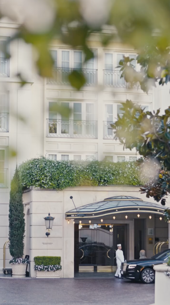 Exterior of the Peninsula Beverly Hills hotel, with a Rolls-Royce and a valet at the entrance.
