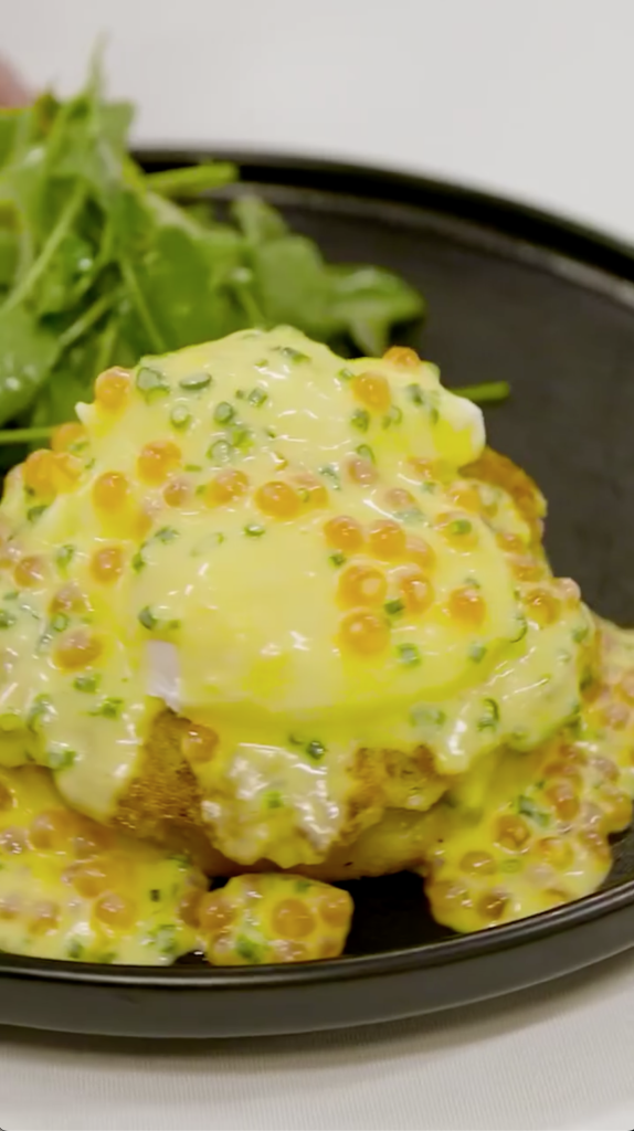 Breakfast Benedict with poached eggs, hollandaise, and caviar on toast.