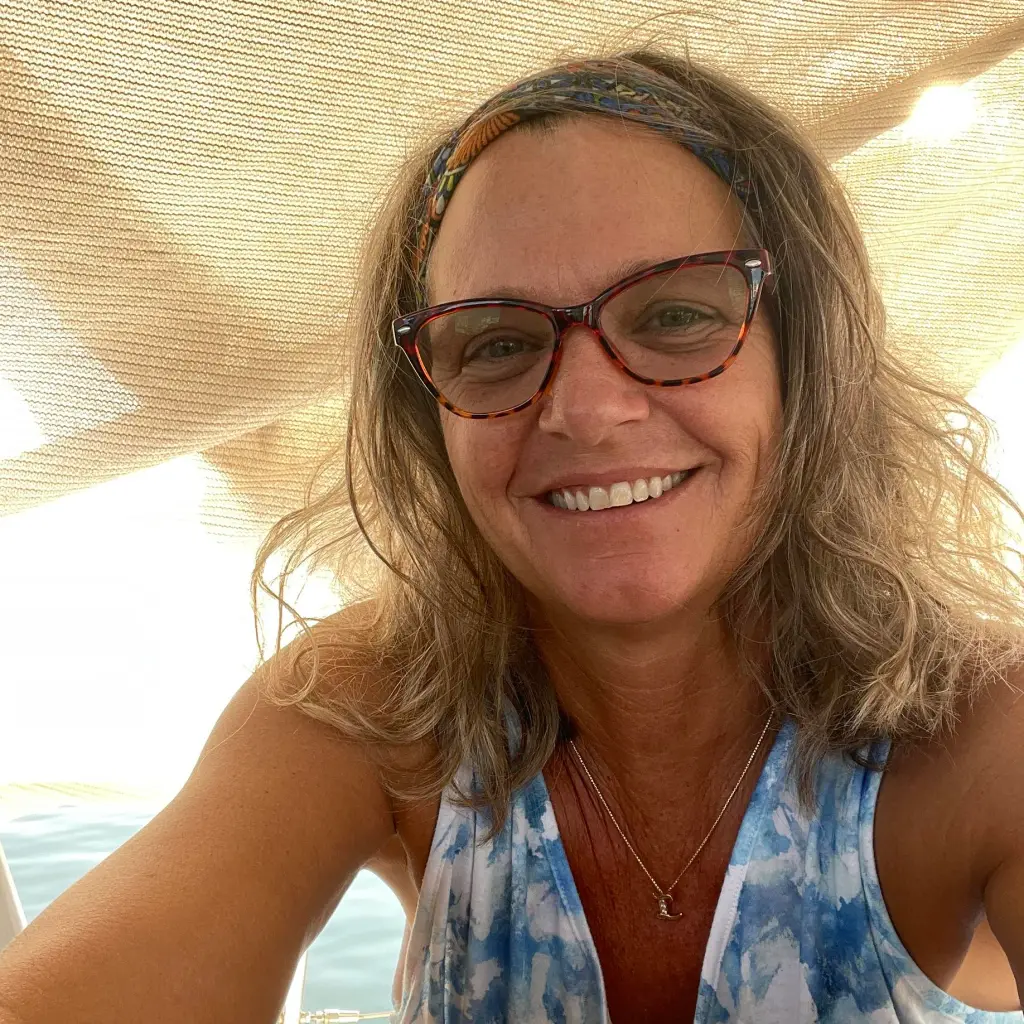 Lynette Hooker smiling under a sunshade.