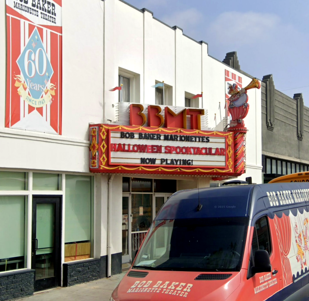 The iconic Bob Baker Marionette Theater with "Halloween Spooktacular Now Playing" on the marquee, and a Bob Baker Marionette Theater van parked in front.