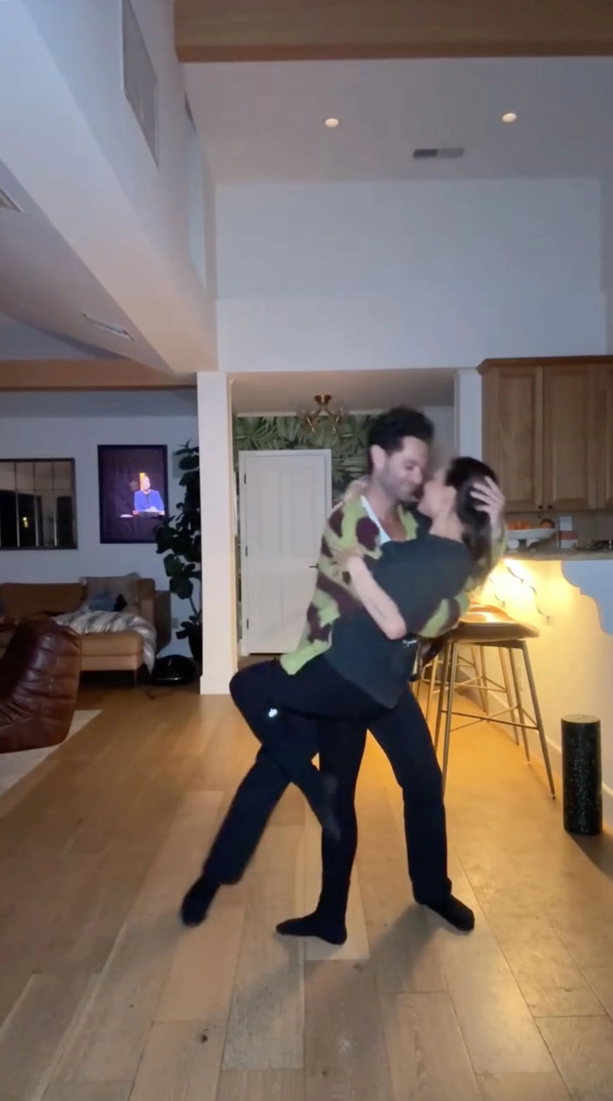 Sasha Farber holding Janel Parrish while dancing.