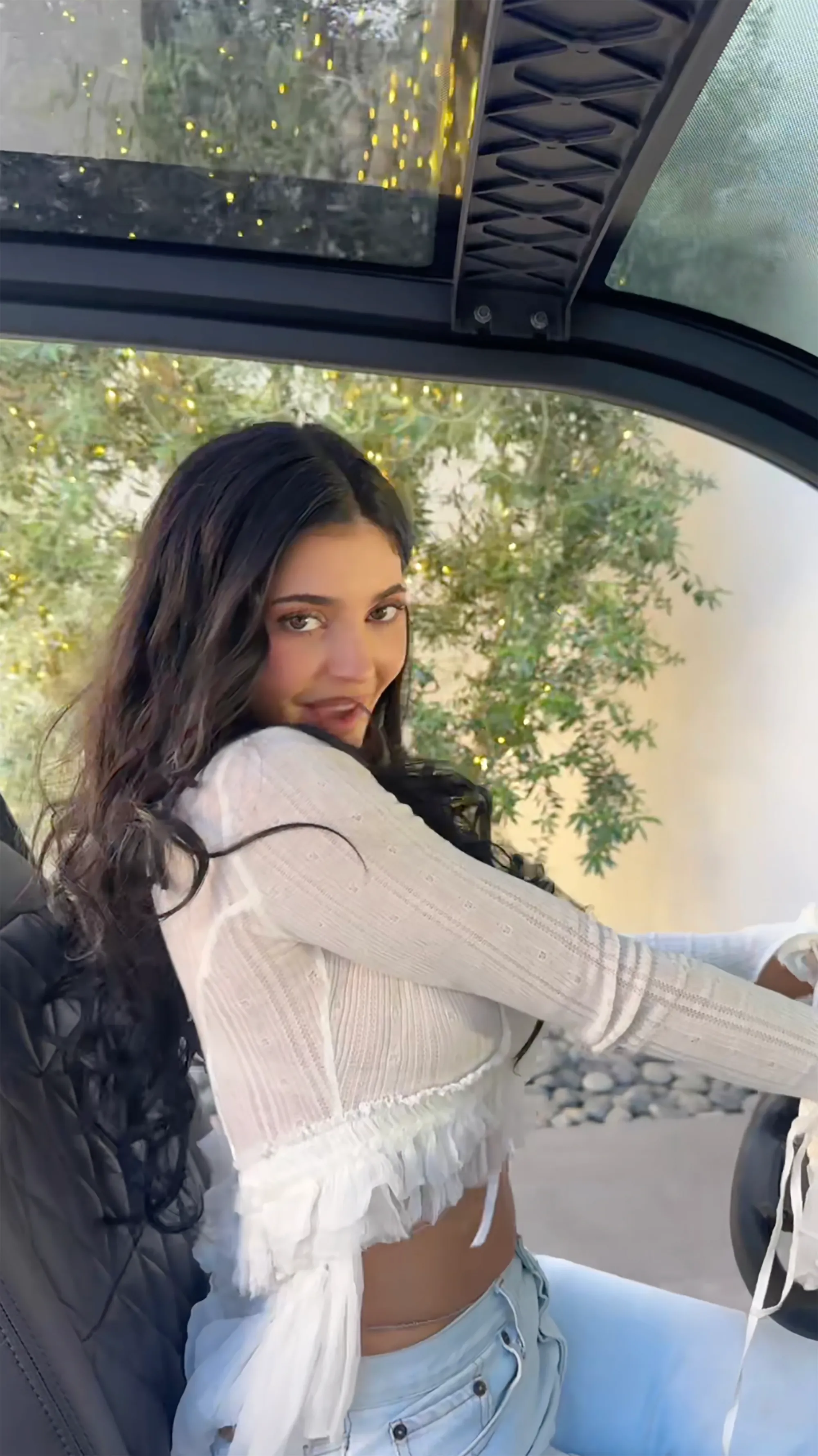 Kylie Jenner in a golf cart looking over her shoulder.