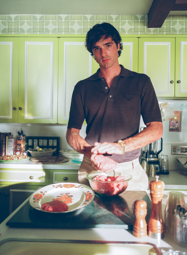 Jacob Elordi making meat patties in a retro-style kitchen.