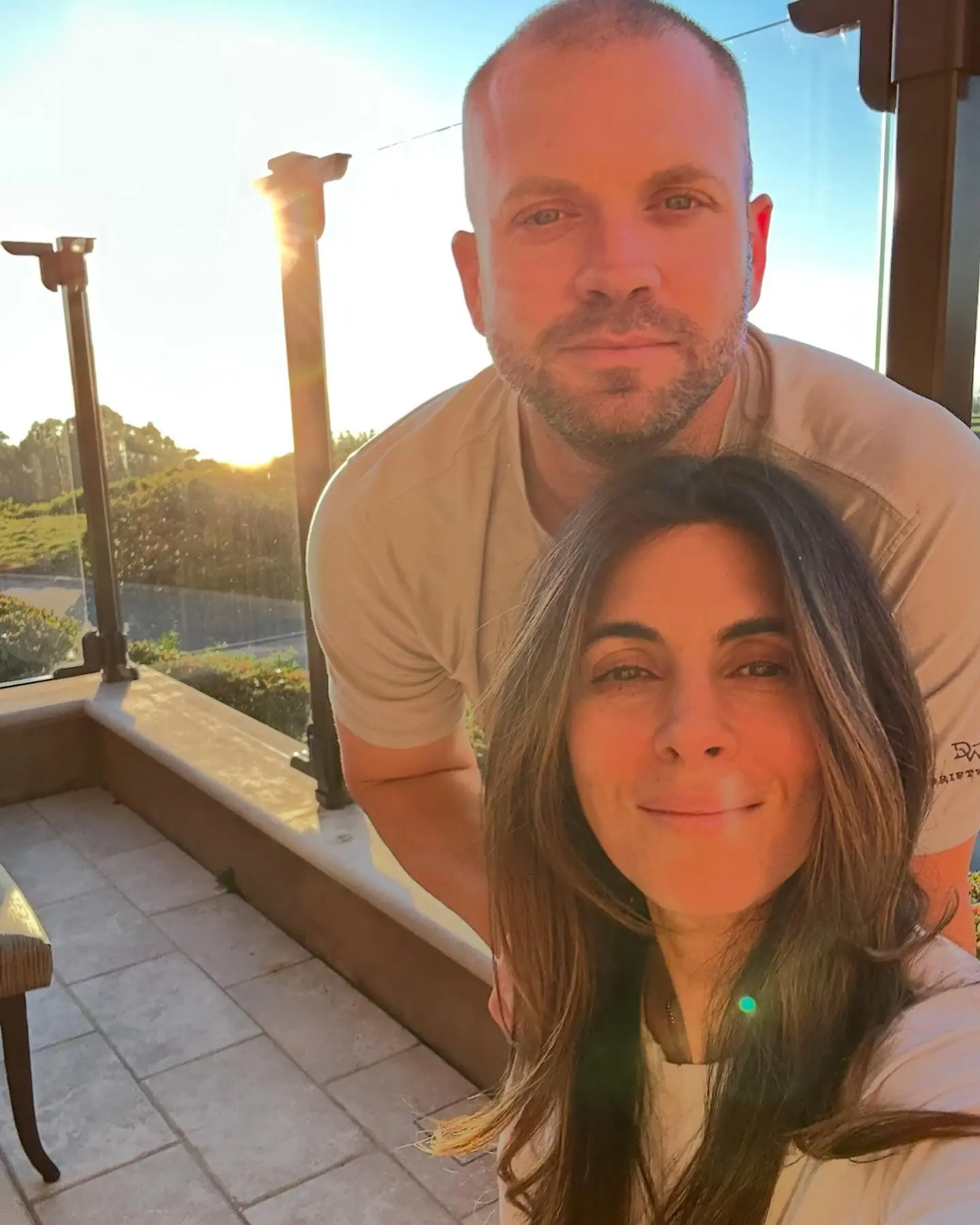 Jamie-Lynn Sigler and her husband posing for a selfie outdoors during sunset.