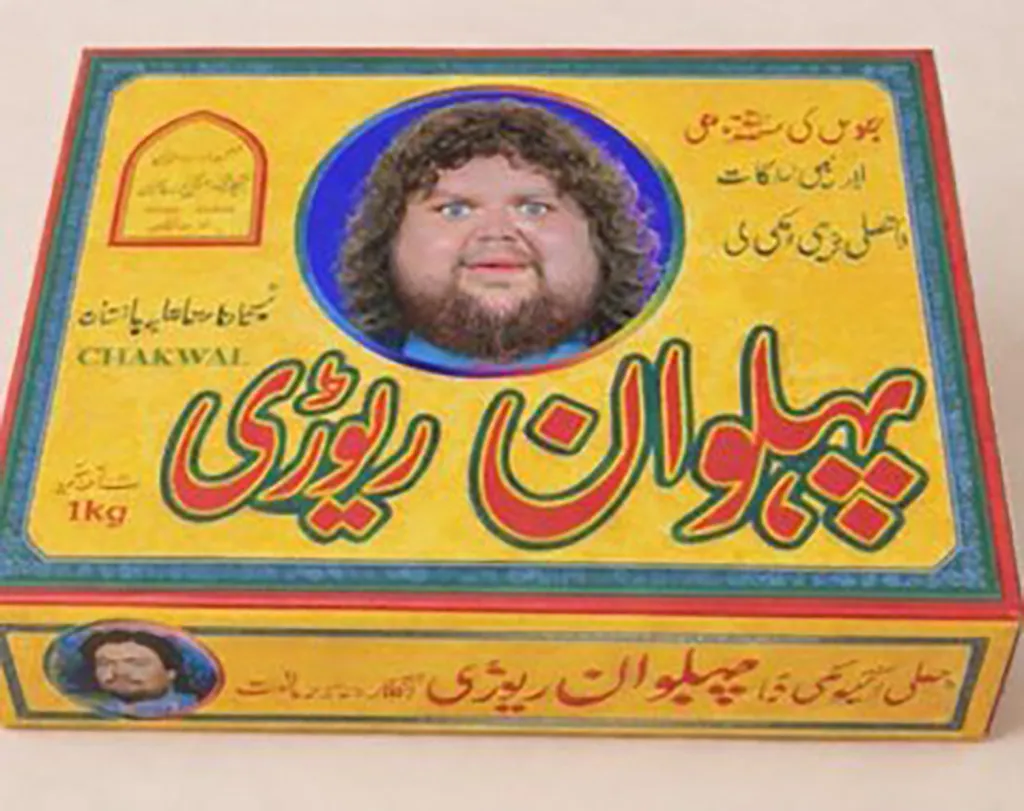 Illustration of a yellow box with a picture of a man with curly hair and a beard, labeled "Pehlwan Rewari."