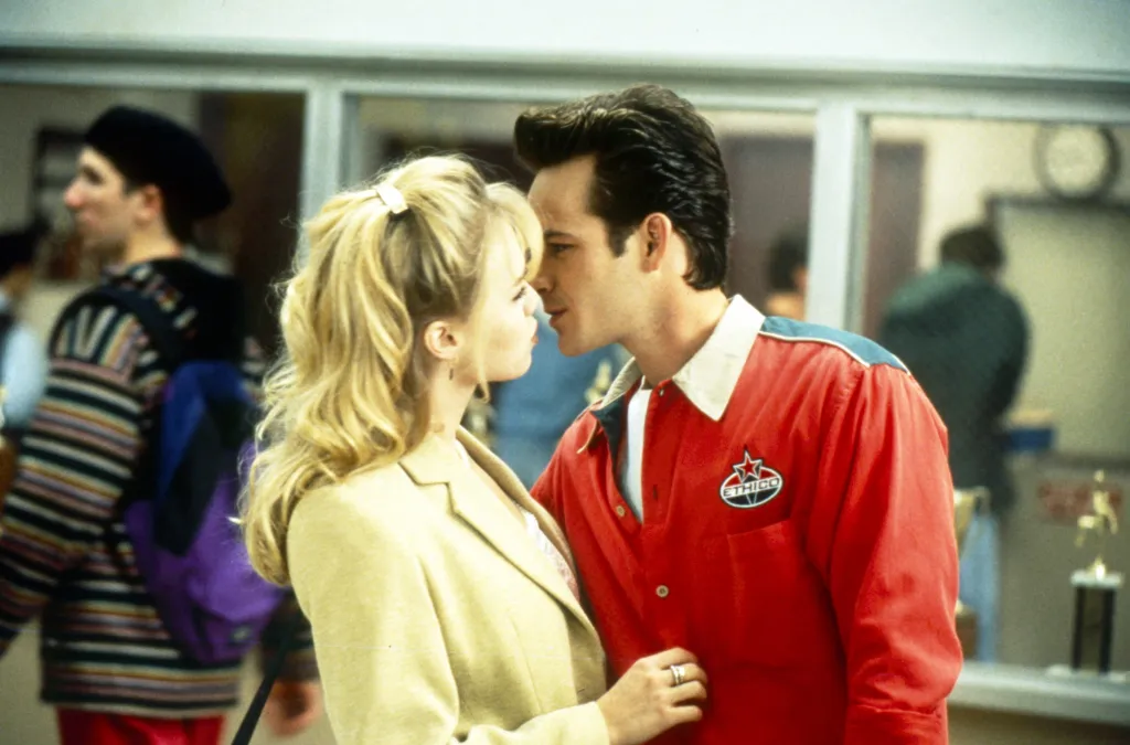 Jennie Garth and Luke Perry as characters Kelly Taylor and Dylan McKay leaning in to kiss on Beverly Hills, 90210.