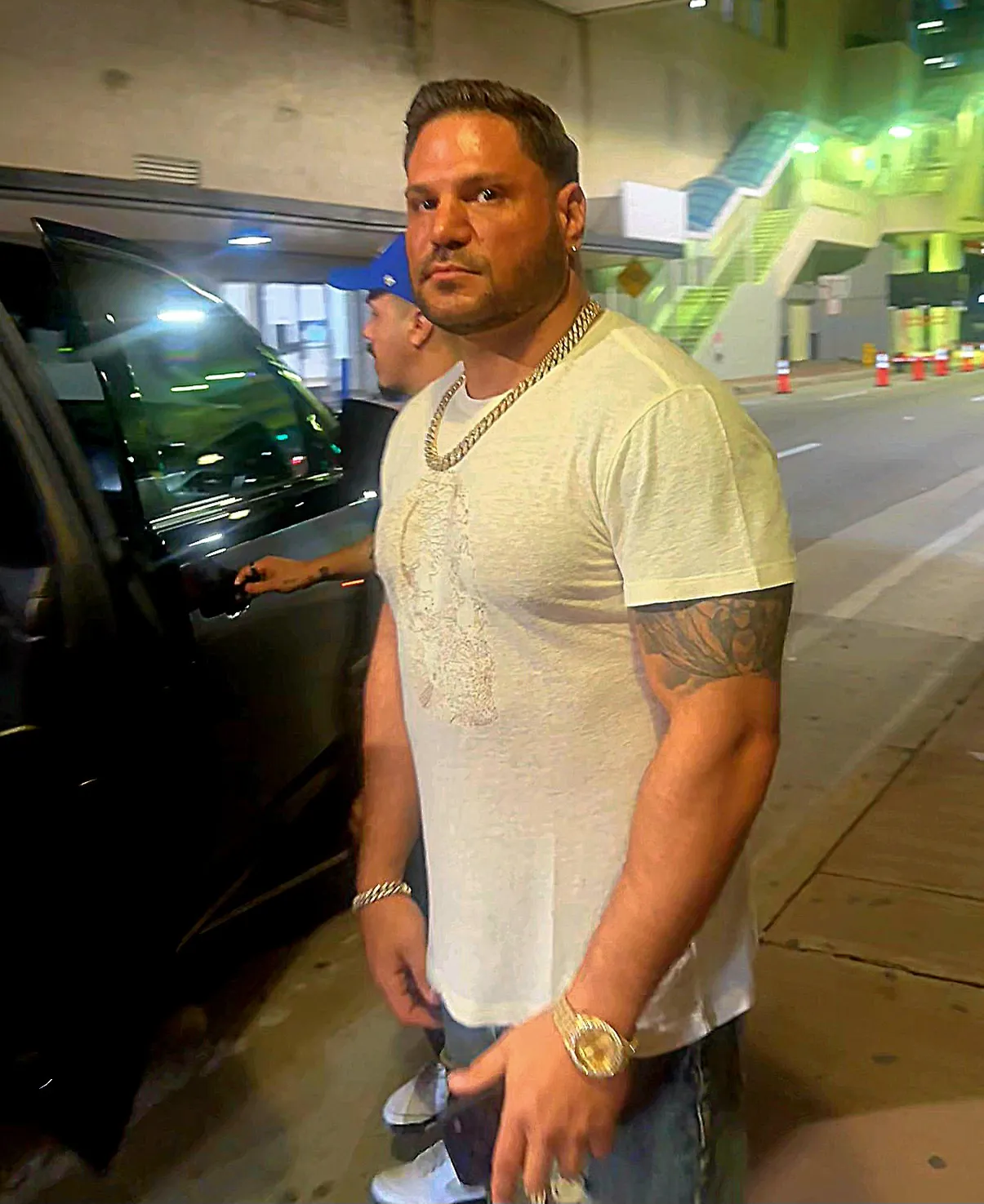 Ronnie Ortiz-Magro in a white t-shirt and gold chain standing outside a car.