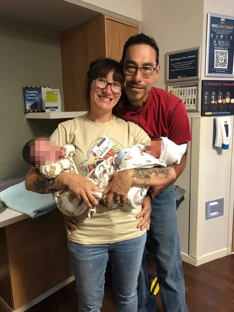 Jessica McClure Morales and Danny Morales holding their two grandchildren.