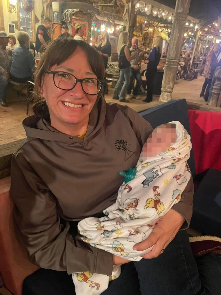 Jessica McClure Morales smiles while holding her grandchild.