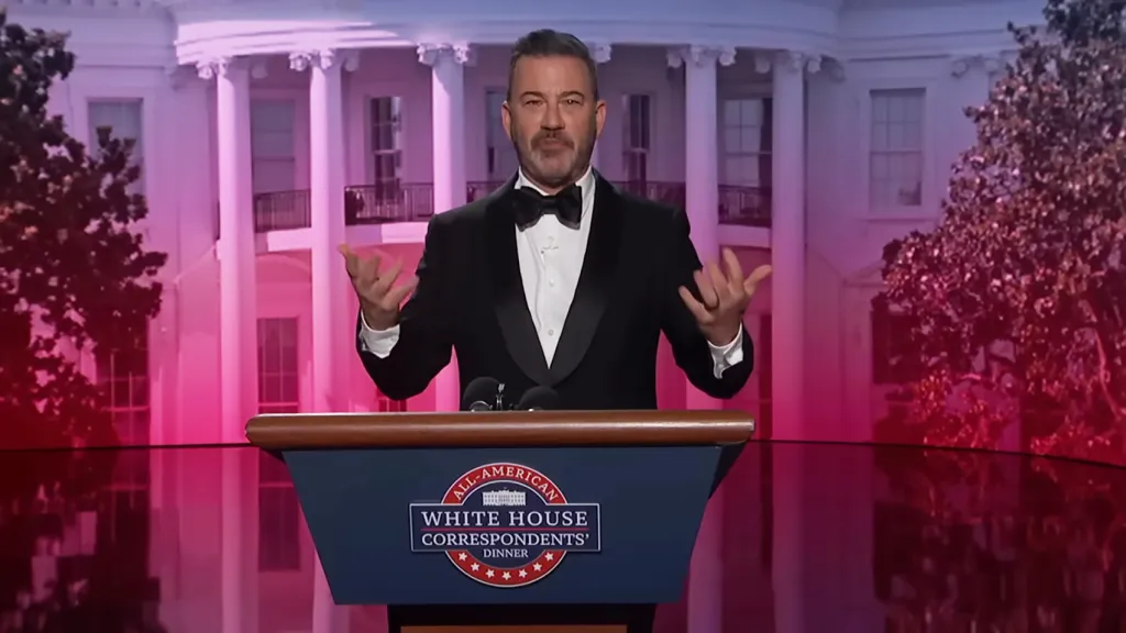 Jimmy Kimmel at a podium with the White House in the background.
