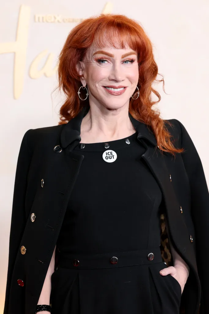 Kathy Griffin with red hair and a black outfit, wearing an "ICE OUT" button, at the "Hacks" Season 5 premiere.