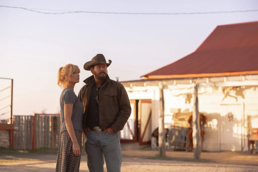 Beth Dutton and Rip Wheeler standing side-by-side outdoors.