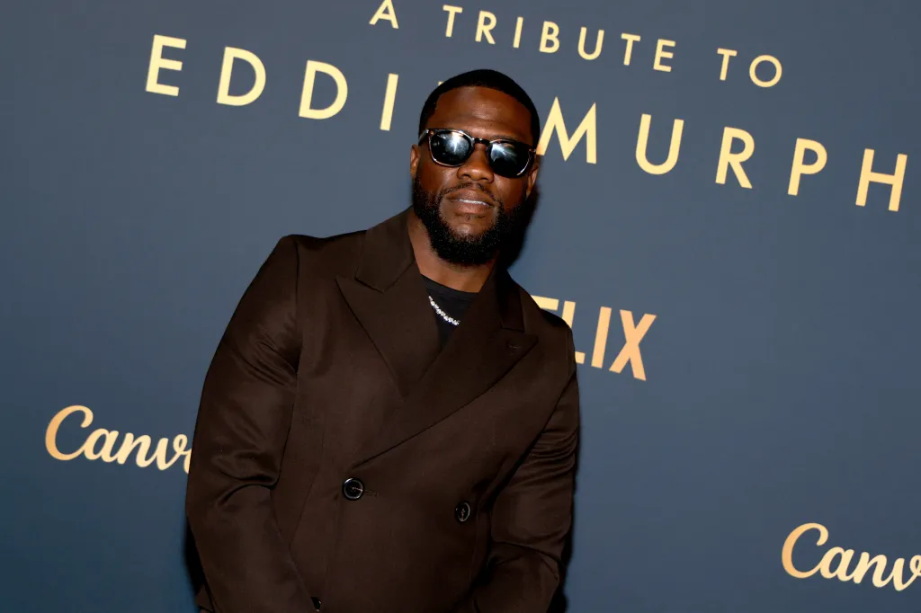 Kevin Hart wearing sunglasses and a brown suit at the 51st AFI Life Achievement Award: A Tribute To Eddie Murphy.