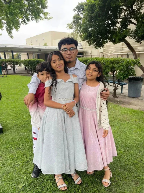 Khimberly Zavaleta Chuquipa and her family standing together on a grassy area.