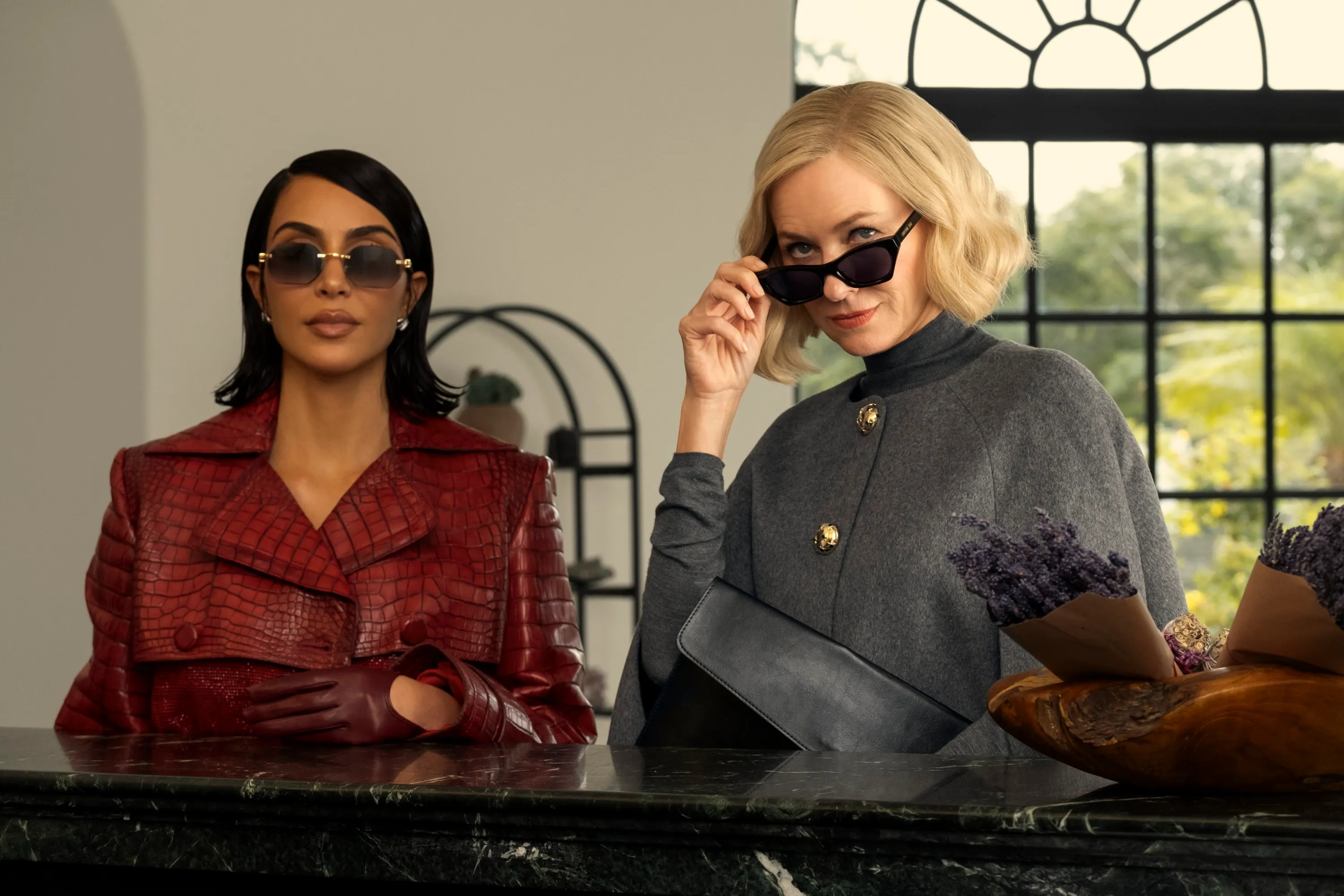 Kim Kardashian and Naomi Watts wearing sunglasses and elegant outfits from the series 