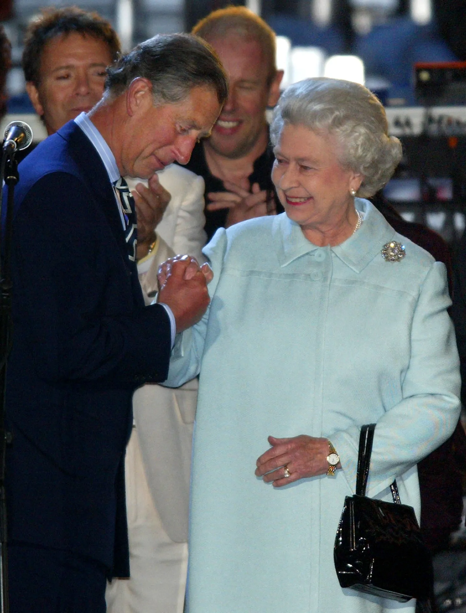 Prince Charles kisses Queen Elizabeth's hand.