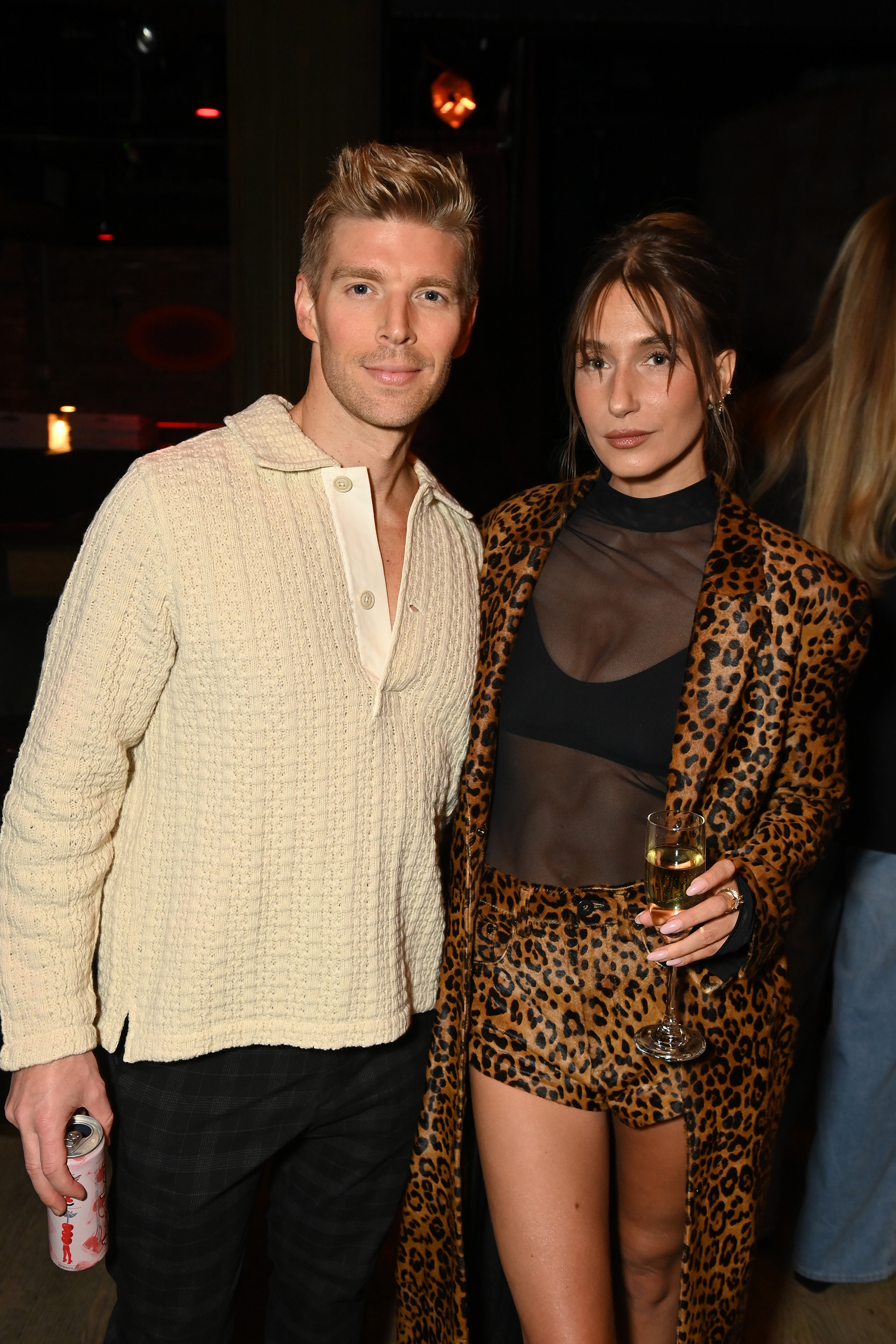 Kyle Cooke and Amanda Batula standing together, looking at the camera.