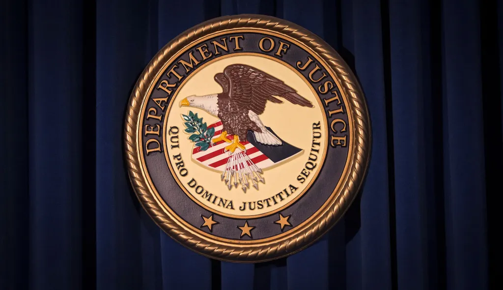 The Department of Justice logo, featuring an eagle and the words "Department of Justice," against a dark blue background.