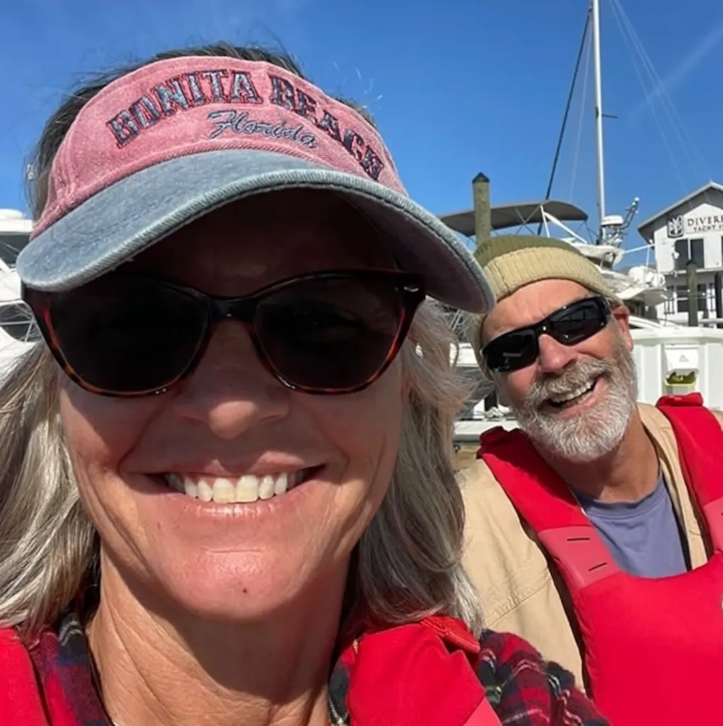 A woman and a man in red life vests smiling.