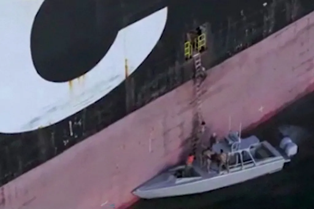 IRGC naval forces boarding a ship from a small vessel with a ladder.