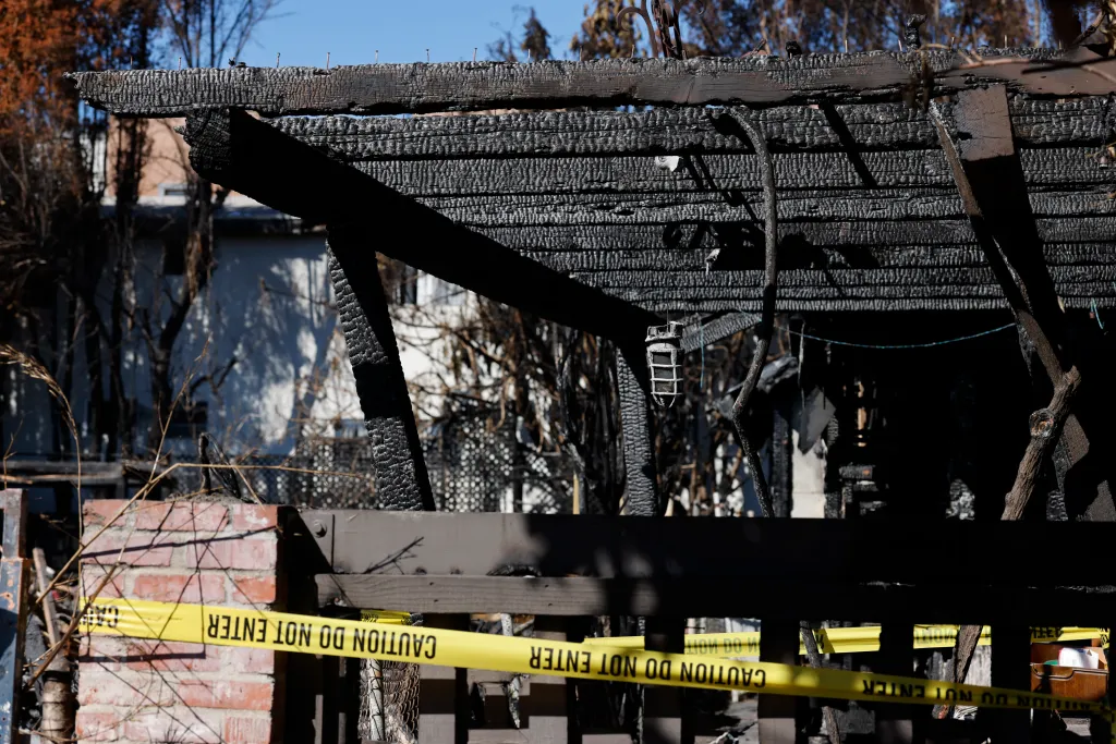 The burnt remains of the Galicia home after an adjacent property caught fire from squatters in Larchmont, with caution tape across the front.