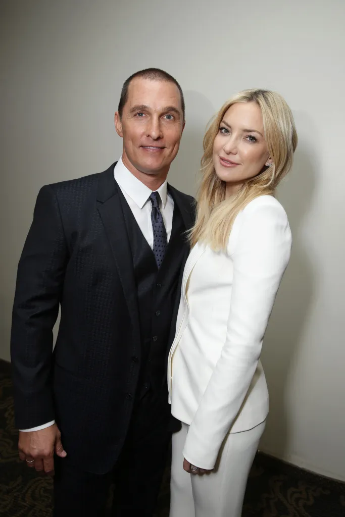 Matthew McConaughey in a suit and Kate Hudson in a white pantsuit pose at the American Cinematheque Award honoring Reese Witherspoon.