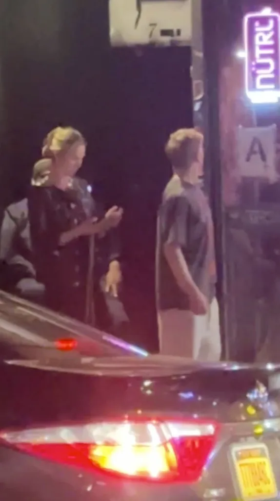 Meghan King Edmonds and Kyle Cooke standing on a sidewalk at night.