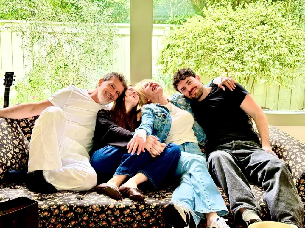 Melanie Griffith and Antonio Banderas with their family on a couch.