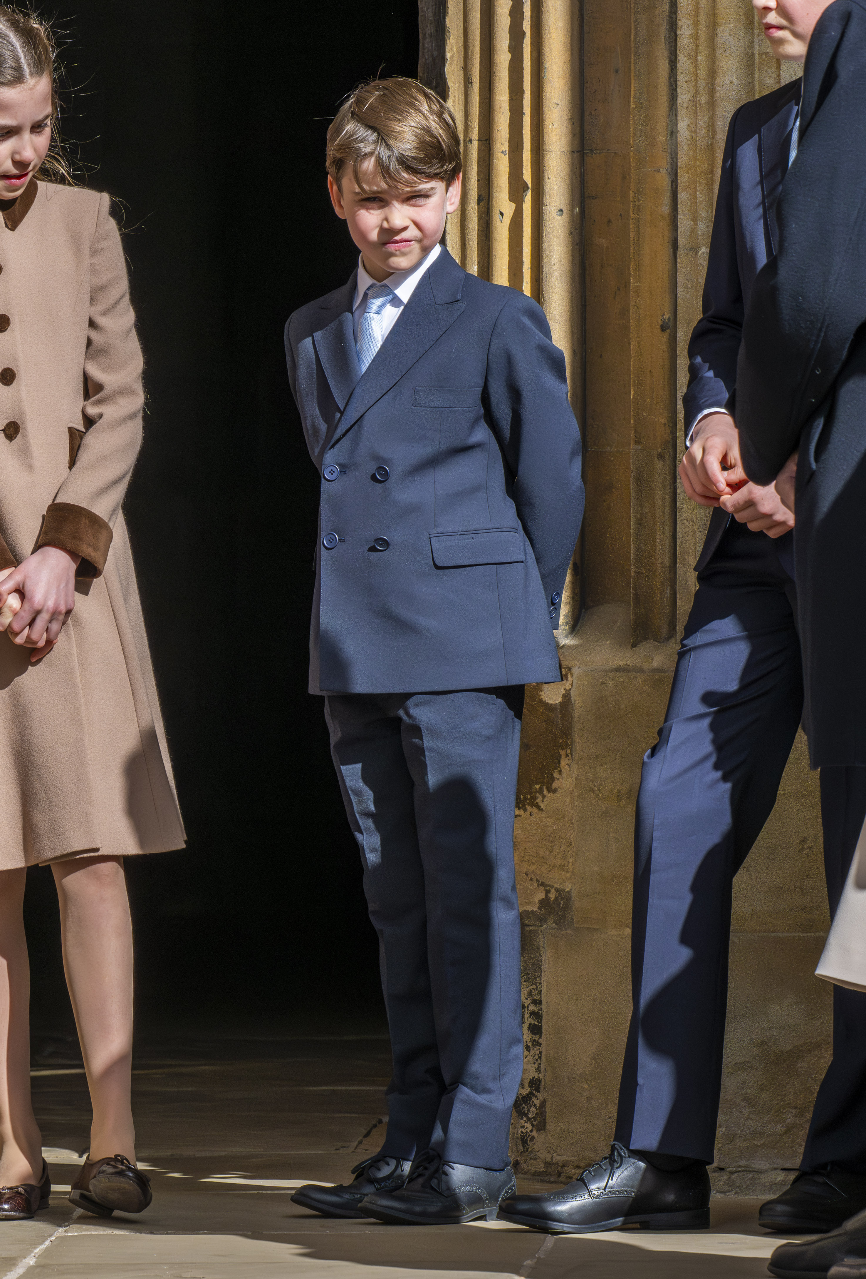 Prince Louis in a navy blue suit with a light blue tie.