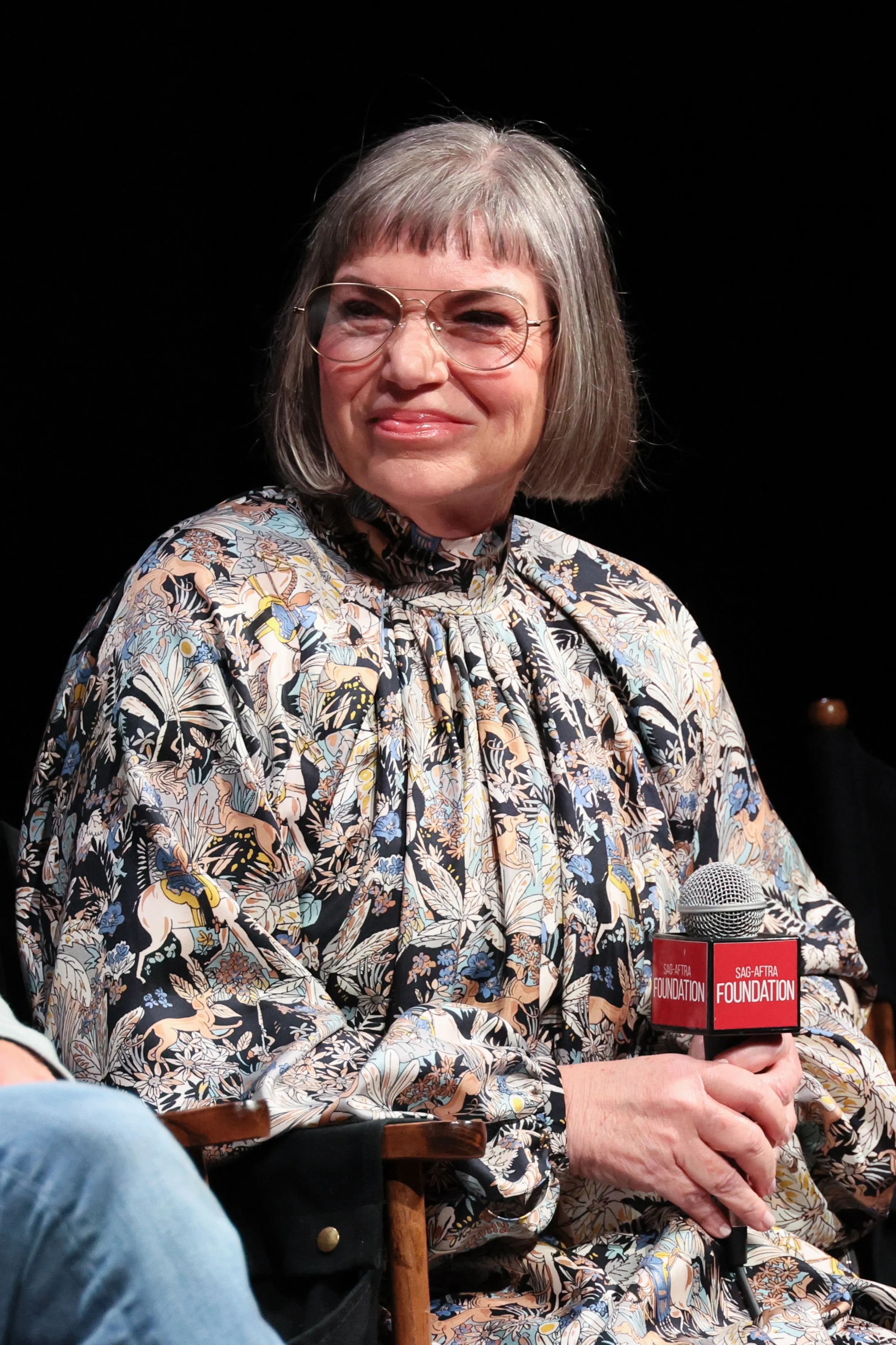 Mindy Cohn smiling while speaking onstage at SAG-AFTRA Foundation Conversations - "Palm Royale".