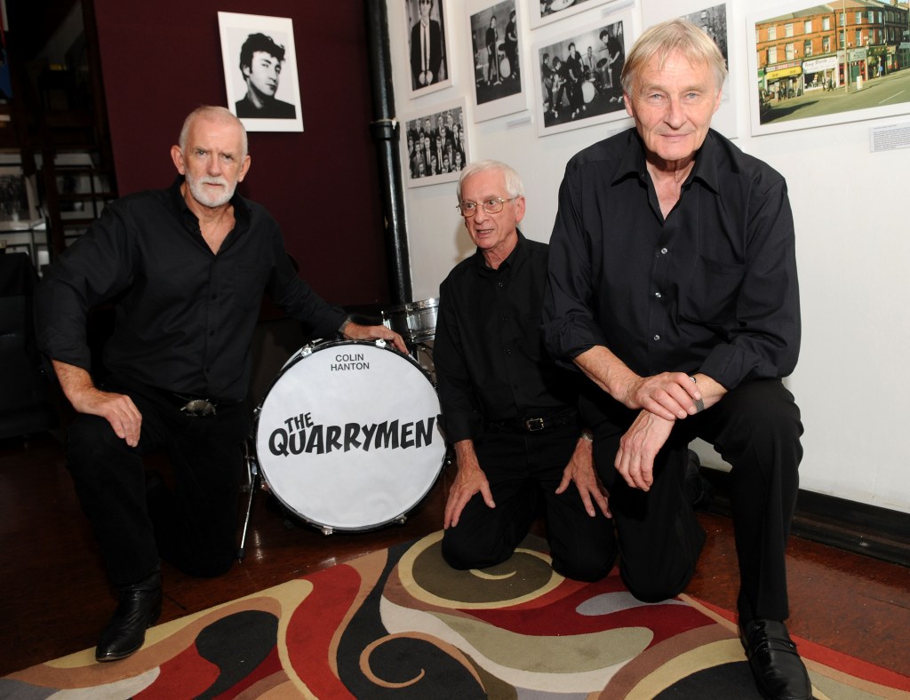 Musicians Rod Davis, Colin Hanton, and Len Garry of The Quarrymen at a photo exhibit.