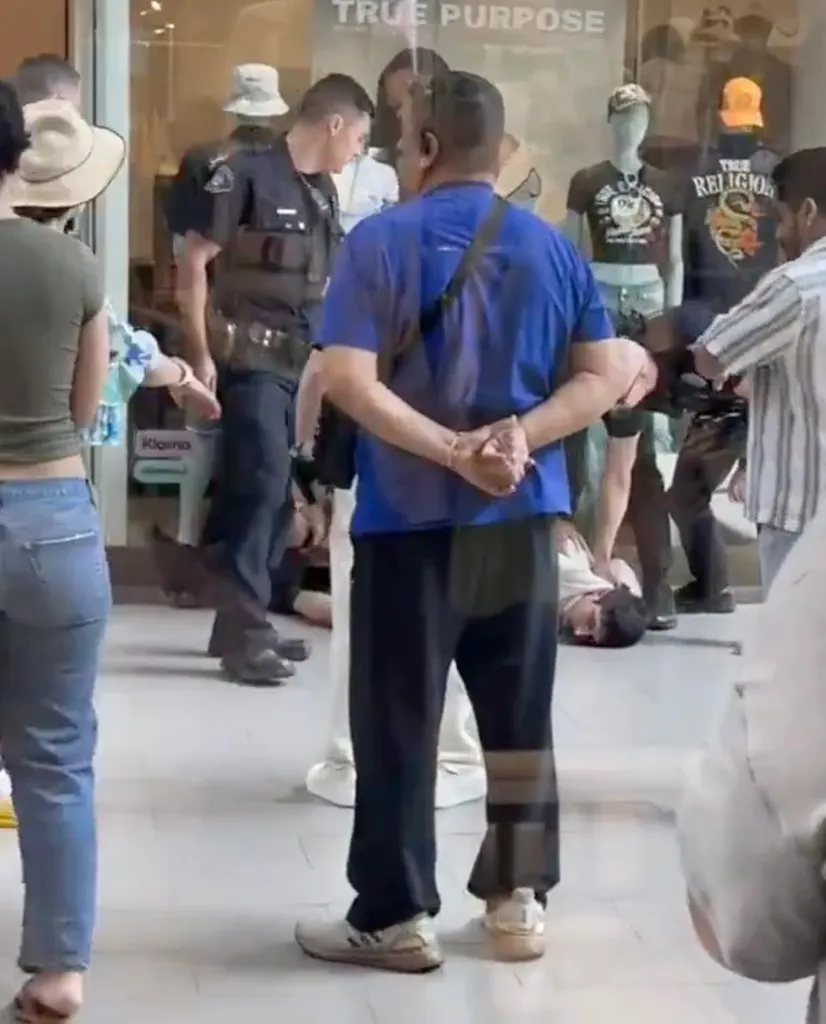 A suspect being detained by police inside a True Religion store.
