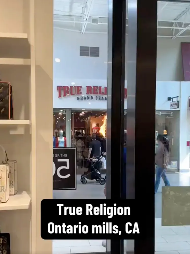 A store interior looking out at the storefront of True Religion, which has flames inside, at Ontario Mills, CA.