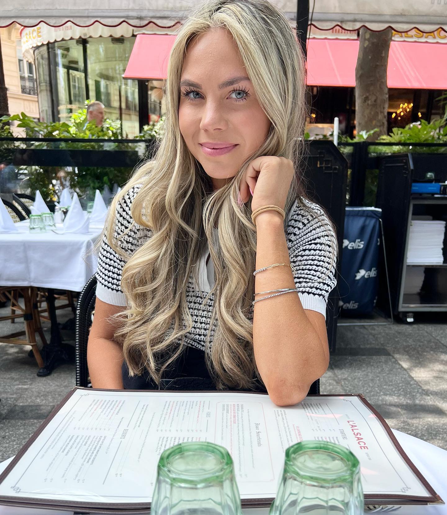 McCall DaPron of The Secret Lives of Mormon Wives: Orange County sitting at an outdoor restaurant.