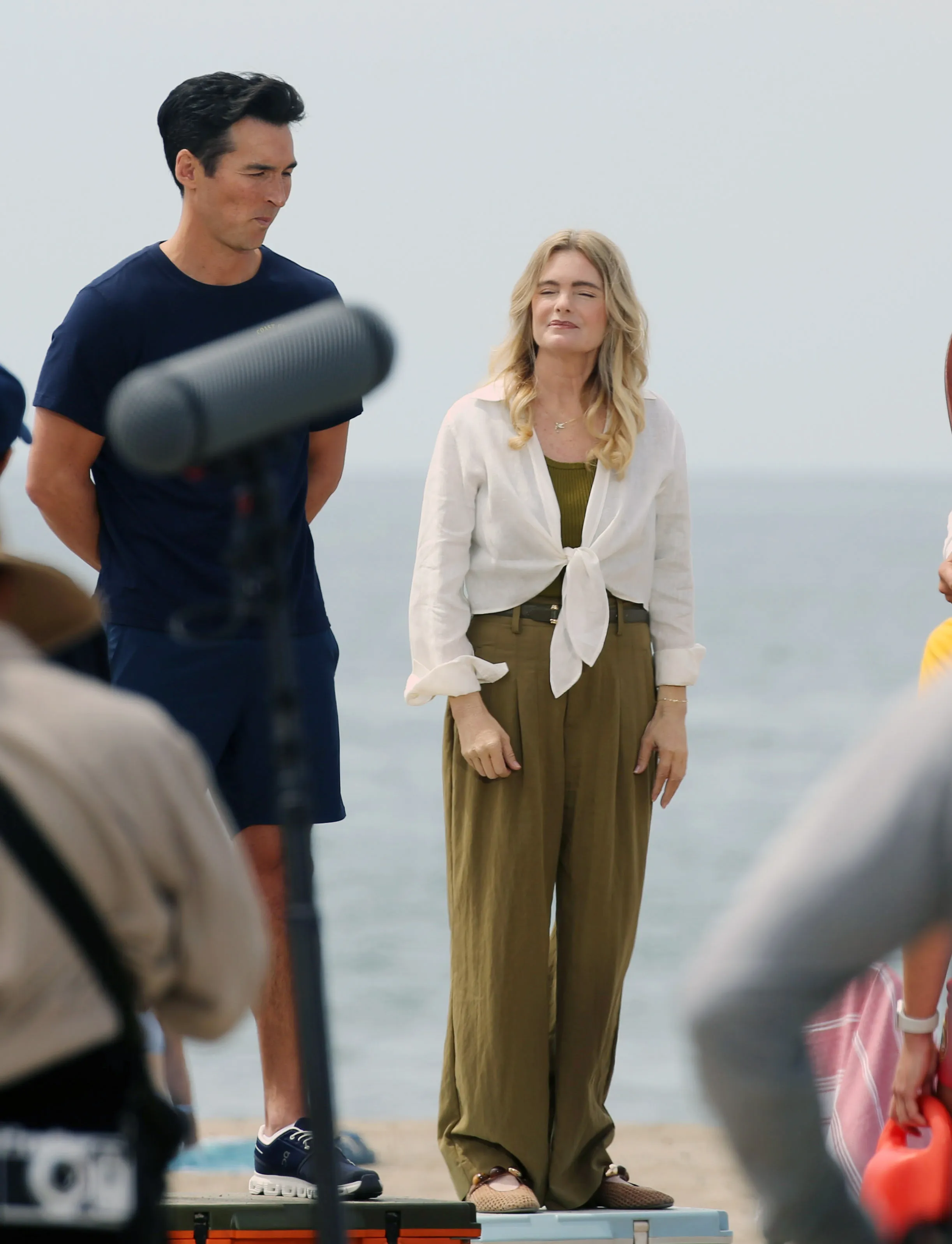 Erika Eleniak and a male co-star filming a Baywatch reboot scene on the beach.