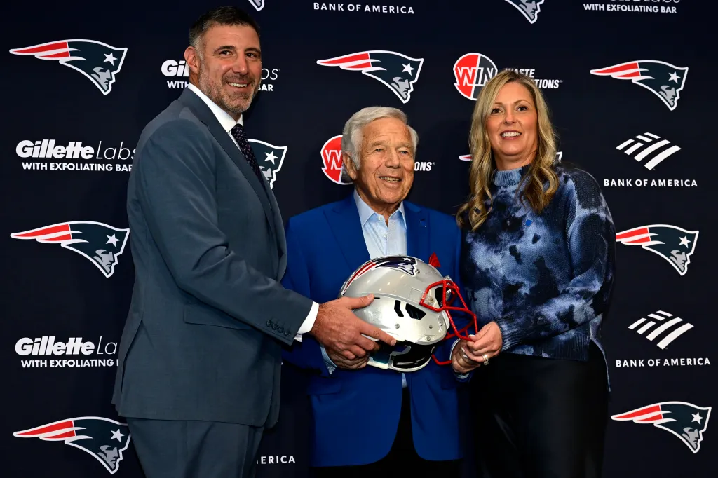 Robert Kraft, Mike Vrabel, and Jen Vrabel posing with a Patriots helmet.
