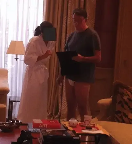 Peter Mandelson wearing only underwear, holding a document, next to a person in a robe.