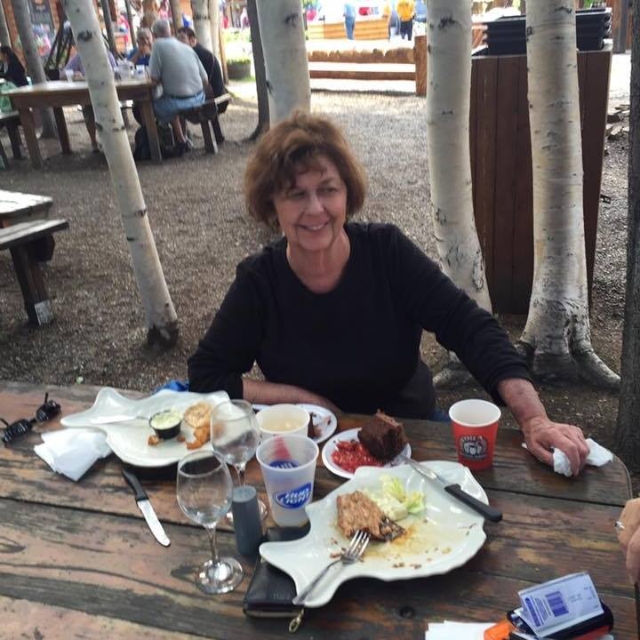 Nancy Guthrie sitting at a picnic table with food.