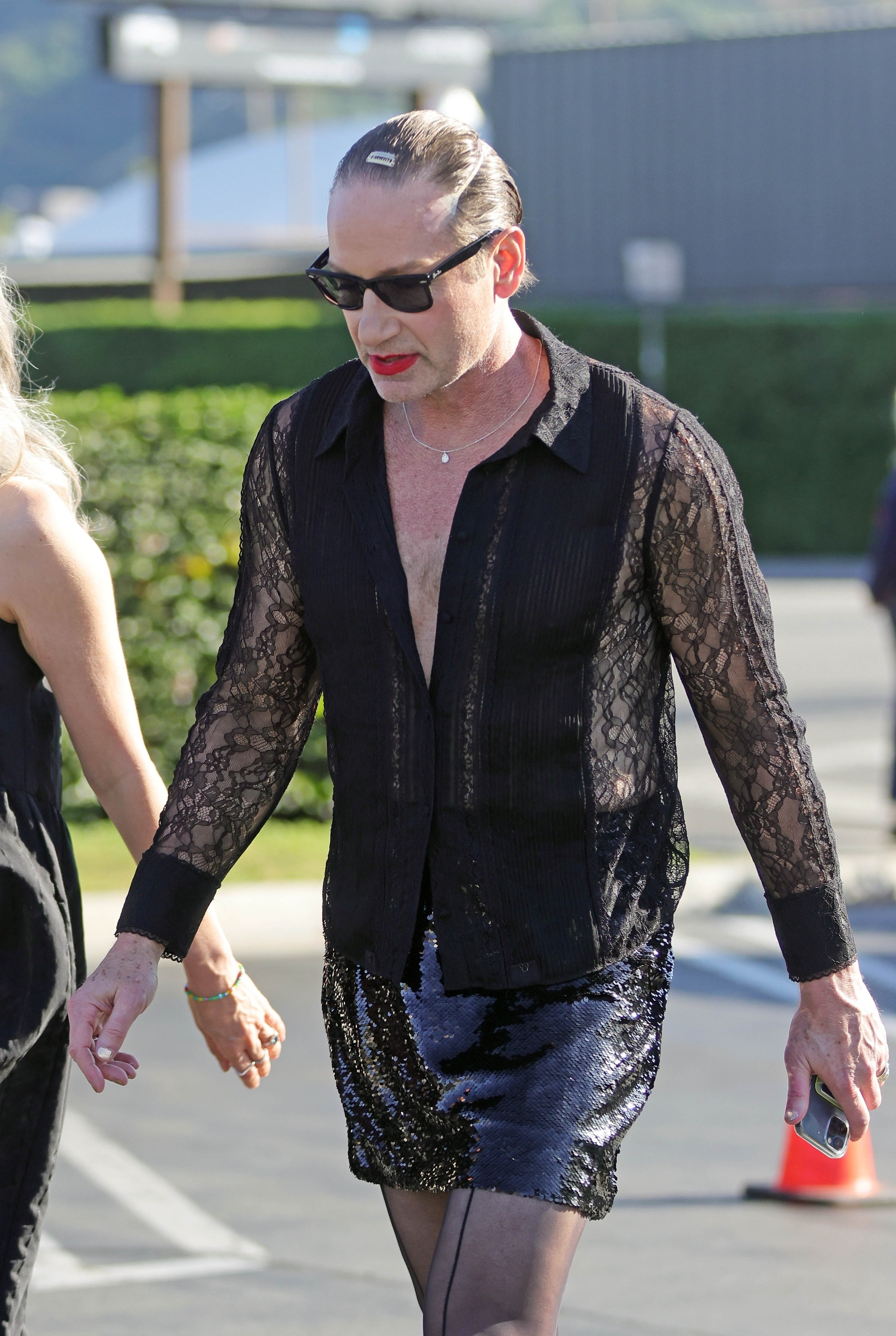 David Duchovny dressed as a woman, wearing a black lace shirt, a sequined skirt, and red lipstick, while filming for the movie "Soapbox."
