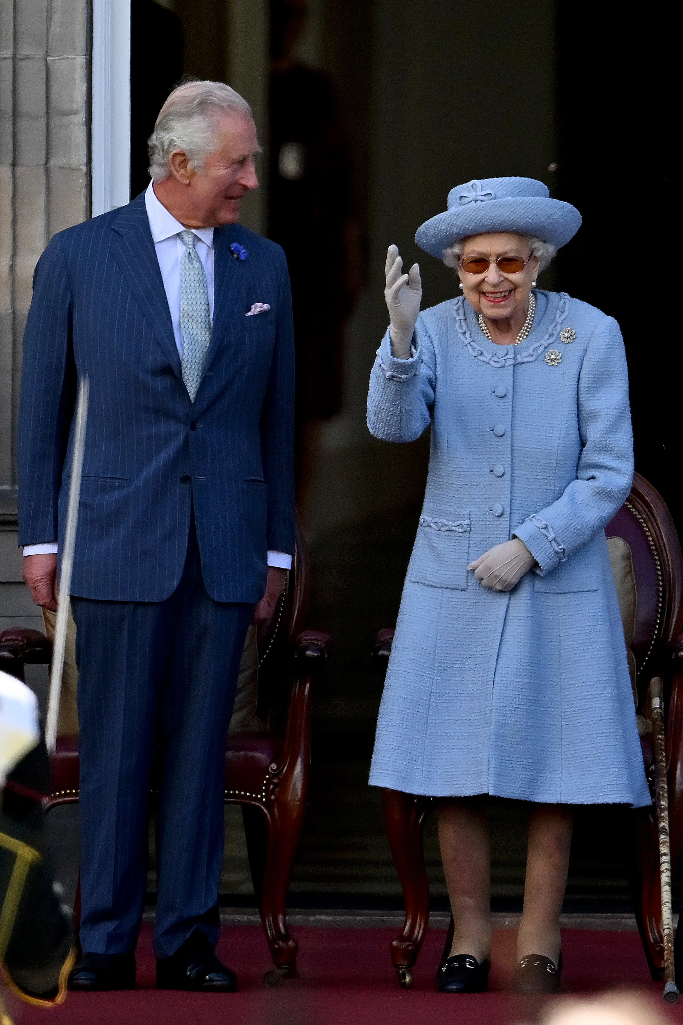 Queen Elizabeth II waves next to Prince Charles.