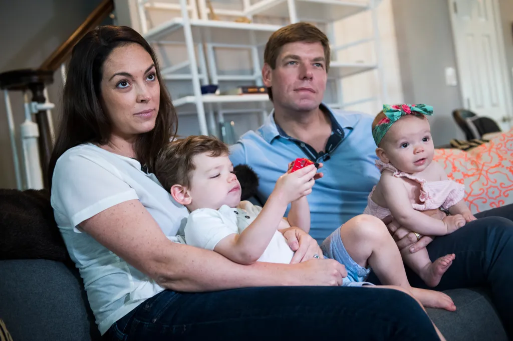 Rep. Eric Swalwell, his wife, and their two children, Nelson and Cricket, sitting on a couch.