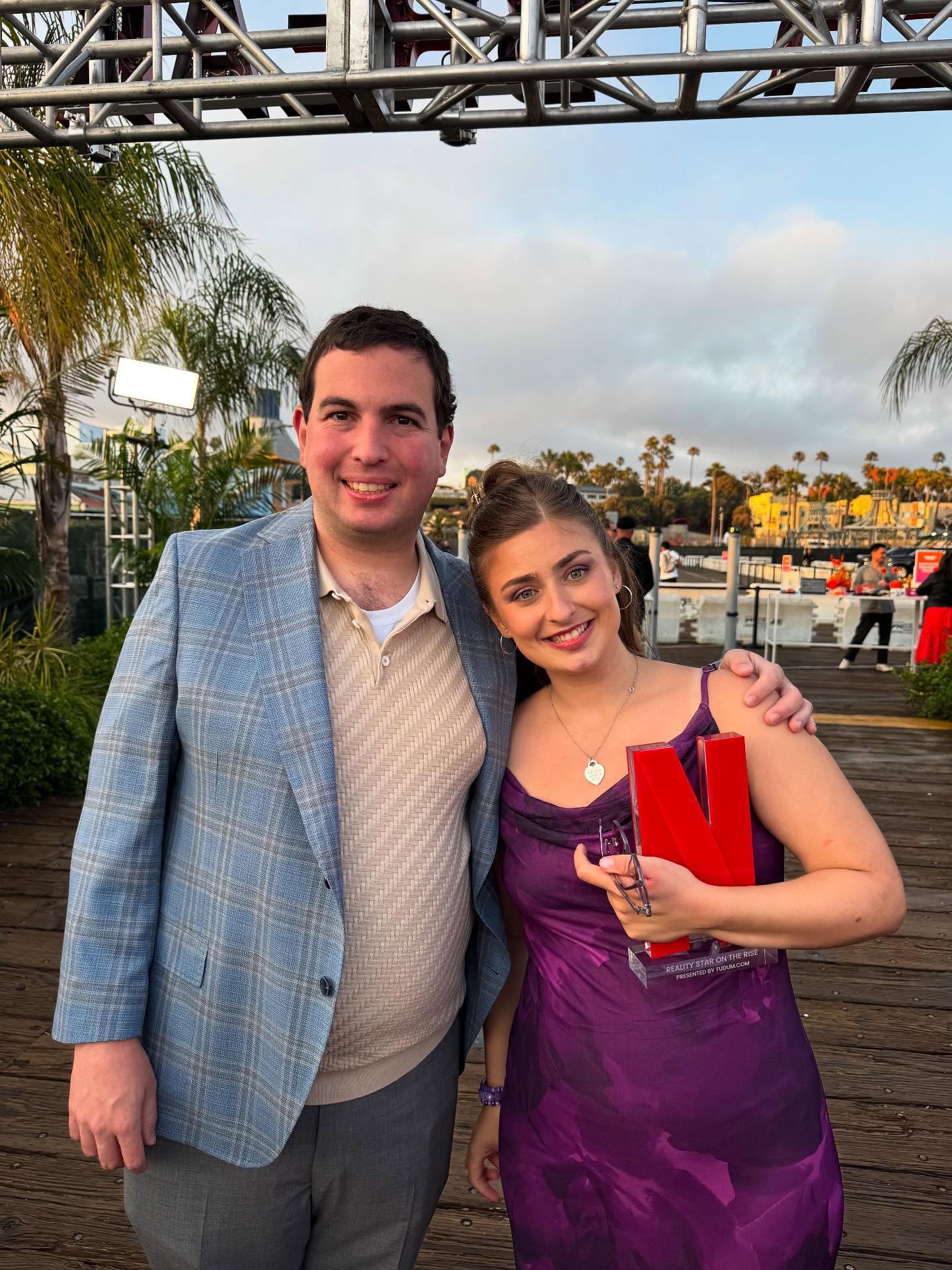 Abbey Romeo and David Isaacman holding an award.