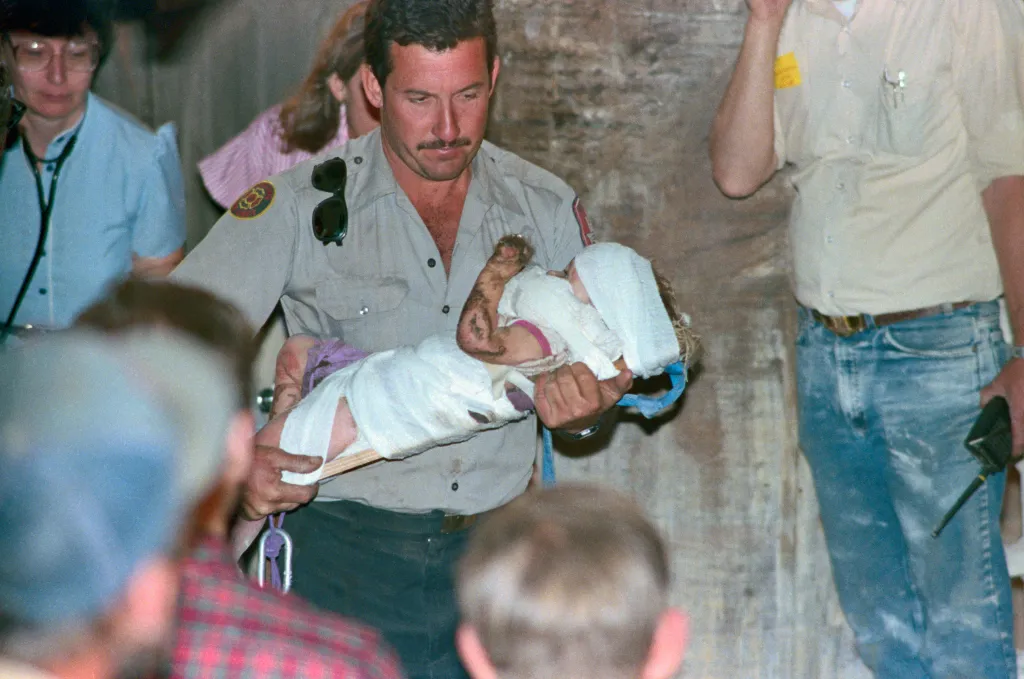 Rescuer carrying baby Jessica McClure after her rescue from a well.