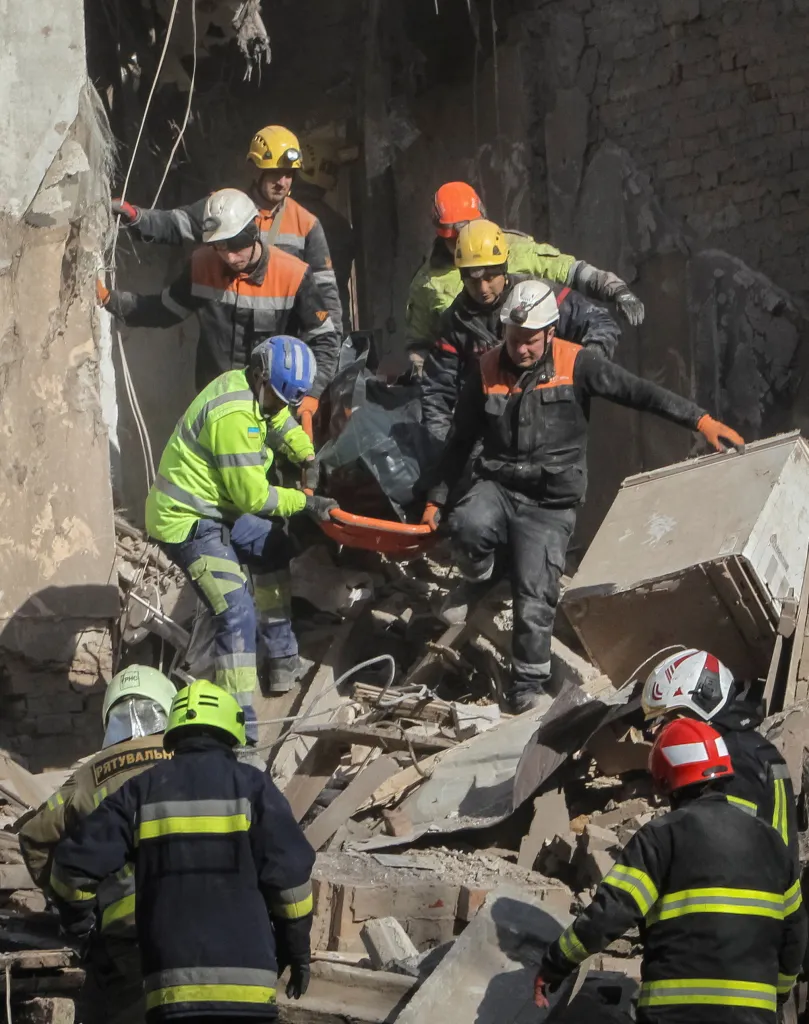 Rescuers carry a body on a stretcher through rubble after a drone and missile strike in Dnipro, Ukraine.