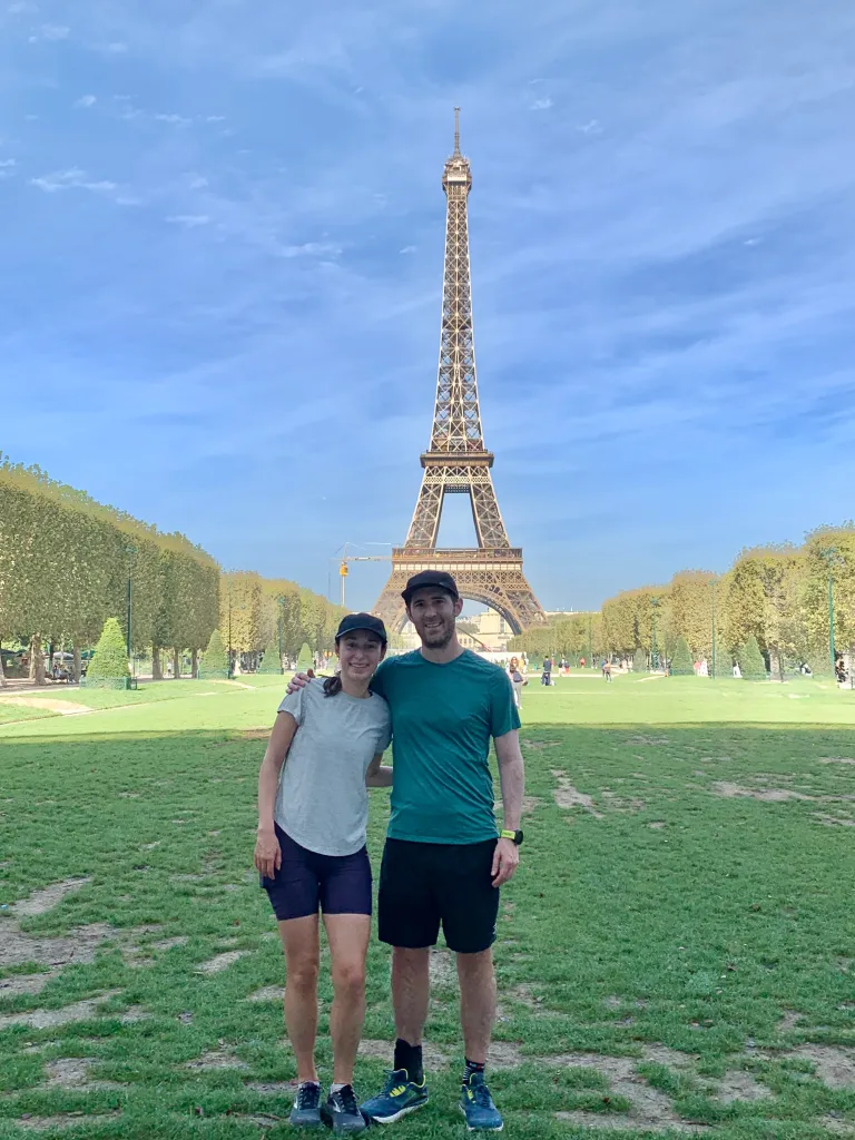 Runner Andy Solarz and another person posing in front of the Eiffel Tower.