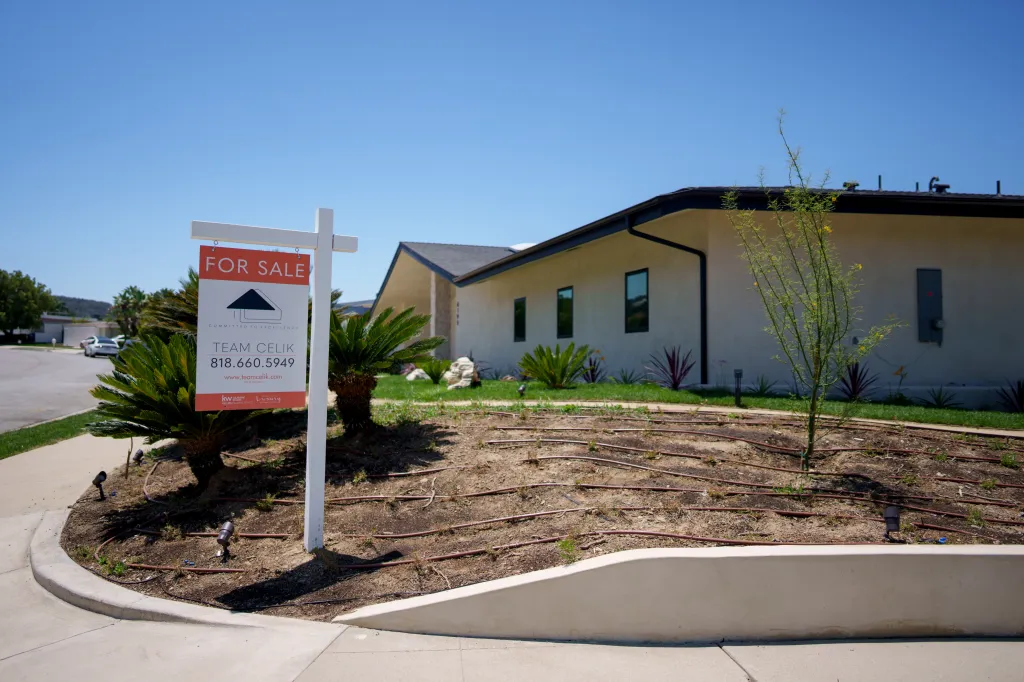 A "For Sale" sign in front of a home in Encino, Los Angeles.