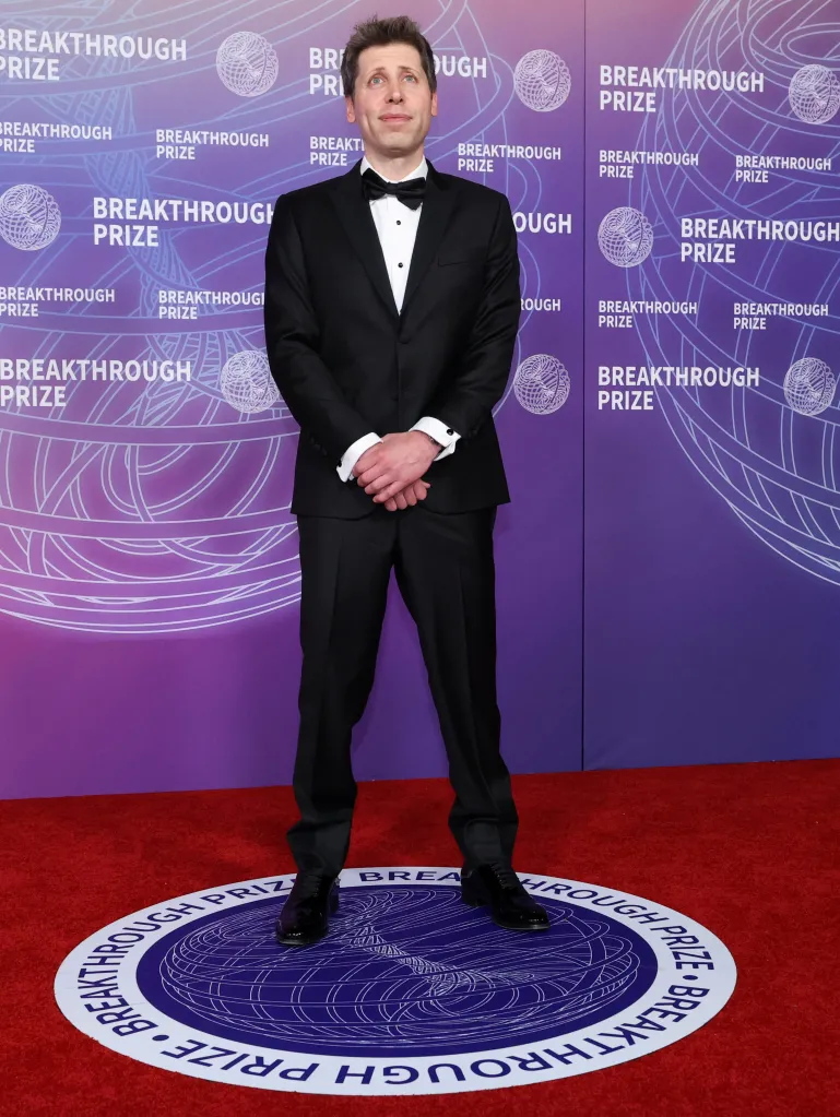 Sam Altman in a black tuxedo on a red carpet with a purple and white "Breakthrough Prize" backdrop.