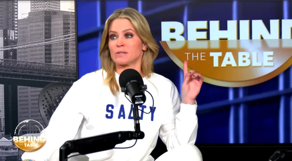 Sara Haines wearing a "Salty" sweatshirt and talking into a microphone, with a "Behind the Table" logo in the background.