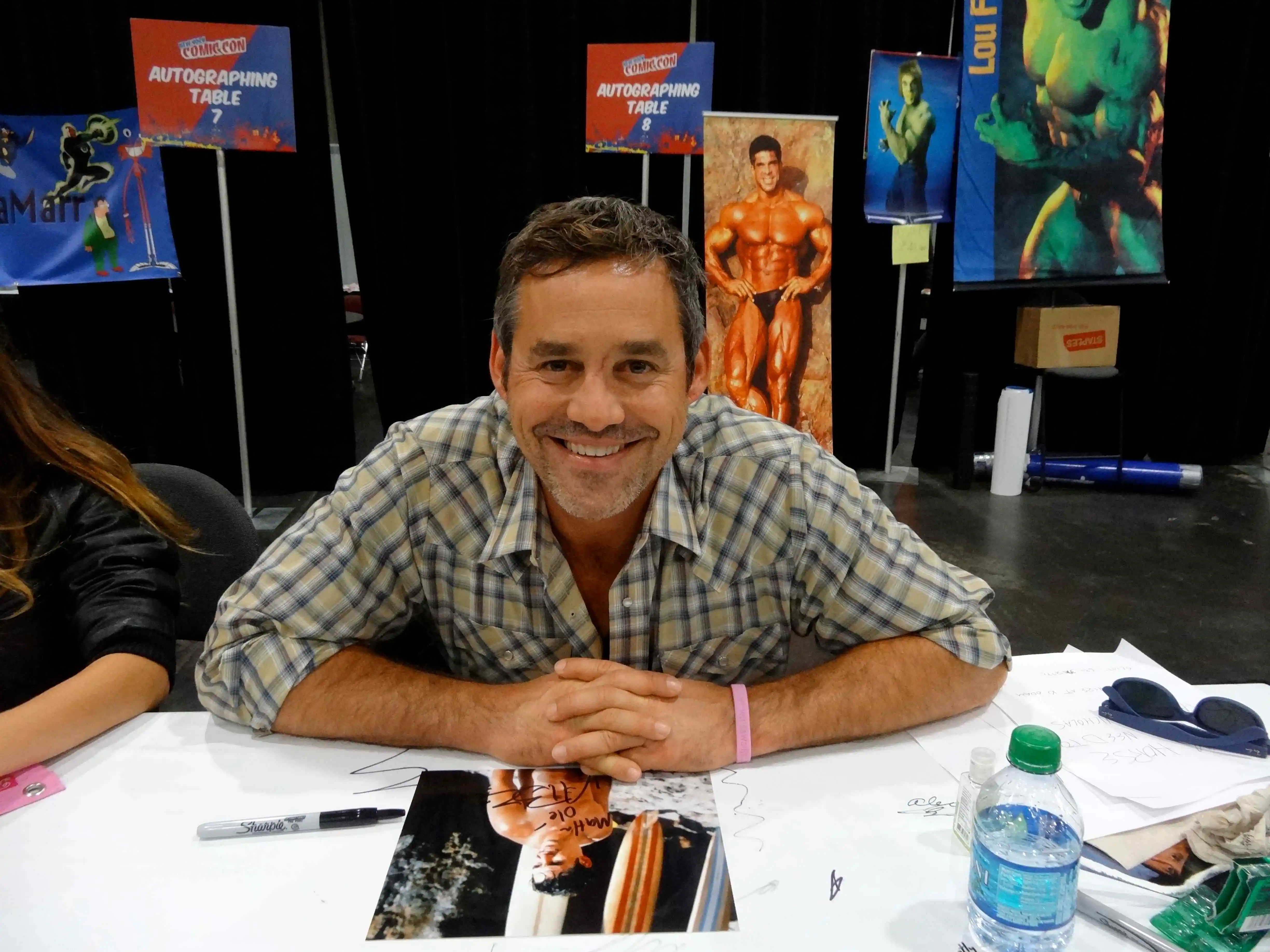 Nicholas Brendon smiling at a Comic-Con autograph table.